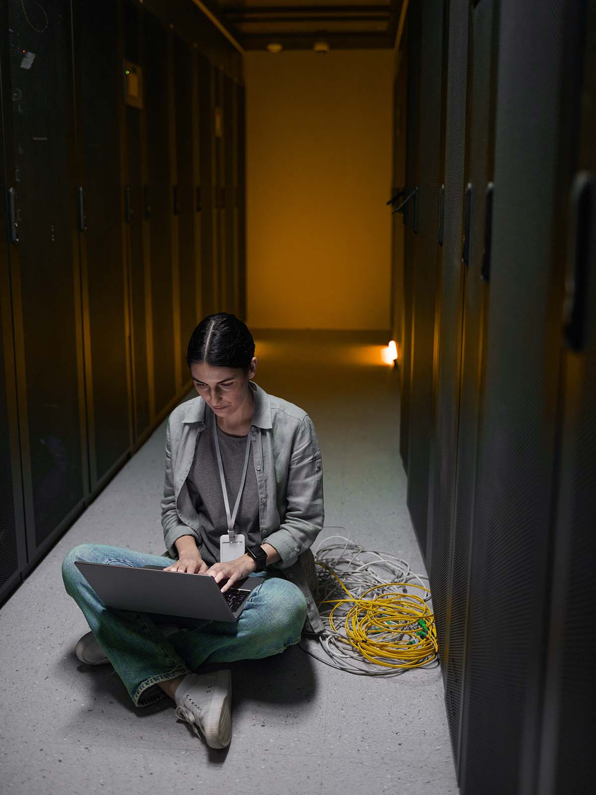 young-woman-sitting-on-floor-in-server-room-T24HZSM.jpg